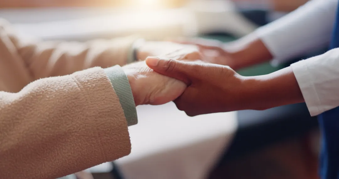 Nurse holding hands with a senior patient for empathy, trust or support of help, advice or healthcare. 